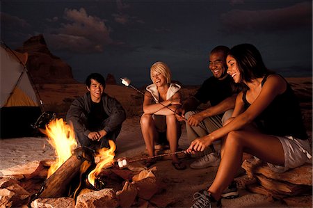 People sitting around a campfire at night Stock Photo - Premium Royalty-Free, Code: 640-03255674