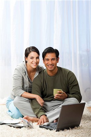 sweatshirt - Man and woman on carpet with laptops Stock Photo - Premium Royalty-Free, Code: 640-03255776