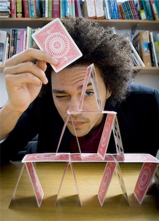 pyramid playing cards - Man making a pyramid out of playing cards Stock Photo - Premium Royalty-Free, Code: 640-03256014