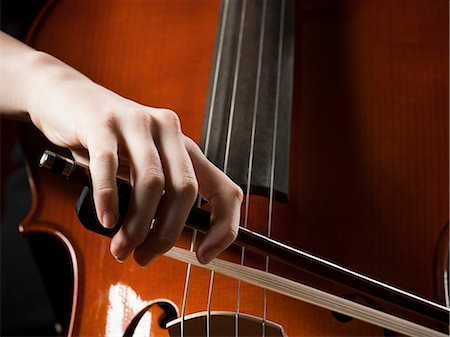 Close-up of young woman playing cello Stock Photo - Premium Royalty-Free, Code: 640-03256793