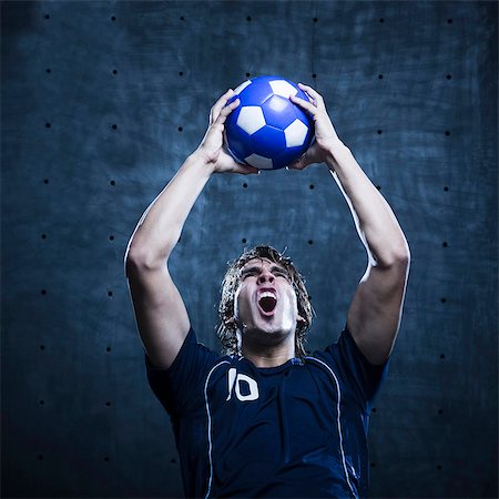 soccer player holding ball - Studio shot of soccer player holding ball and shouting Stock Photo - Premium Royalty-Free, Code: 640-03256915