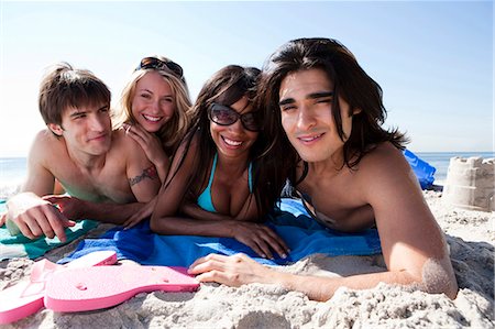 simsearch:640-03258693,k - Quatre adultes, bronzer sur la plage Photographie de stock - Premium Libres de Droits, Code: 640-03258697