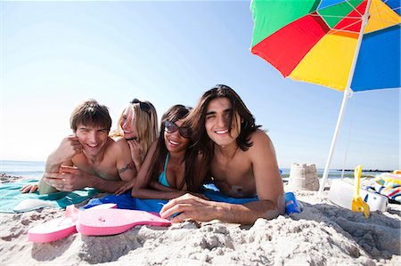 simsearch:640-03258693,k - Quatre adultes, bronzer sur la plage Photographie de stock - Premium Libres de Droits, Code: 640-03258698