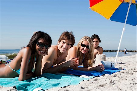 simsearch:640-03258693,k - Quatre adultes, bronzer sur la plage Photographie de stock - Premium Libres de Droits, Code: 640-03258692