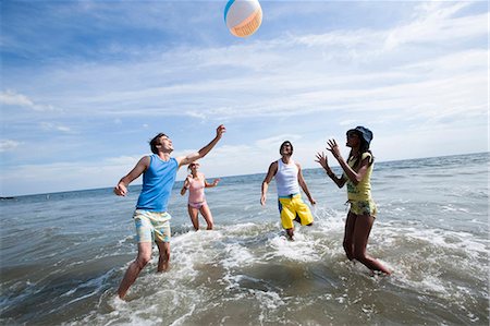 simsearch:640-03258693,k - Quatre adultes jouant avec un ballon de plage Photographie de stock - Premium Libres de Droits, Code: 640-03258779