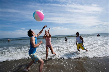 simsearch:640-03258693,k - Trois adultes jouant avec un ballon de plage Photographie de stock - Premium Libres de Droits, Code: 640-03258771