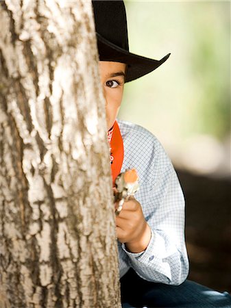 Boy in cowboy costume with toy gun Stock Photo - Premium Royalty-Free, Code: 640-03259357