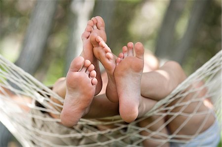 Two pairs of bare feet in a hammock Stock Photo - Premium Royalty-Free, Code: 640-03259809