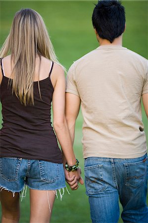 romantic boy and girl - Young couple walking on a lawn arm in arm Stock Photo - Premium Royalty-Free, Code: 640-03259858