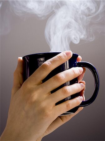 Hand holding hot cup of coffee Stock Photo - Premium Royalty-Free, Code: 640-03264785