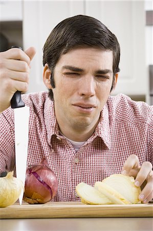 Man slicing onion and crying Stock Photo - Premium Royalty-Free, Code: 640-03264909