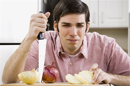 Man slicing onion and crying Stock Photo - Premium Royalty-Free, Code: 640-03264911