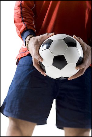 soccer player holding ball - Soccer player holding groin Stock Photo - Premium Royalty-Free, Code: 640-03264987