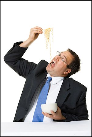 fat man cutout - Businessman awkwardly eating noodles Stock Photo - Premium Royalty-Free, Code: 640-03265125