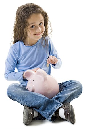 Young girl depositing money in piggy bank Stock Photo - Premium Royalty-Free, Code: 640-03265235