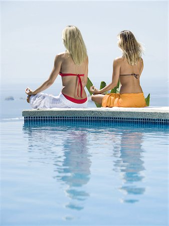 partially dressed - Rear view of a young woman and a mid adult woman sitting in a lotus position at the poolside Stock Photo - Premium Royalty-Free, Code: 640-03265642