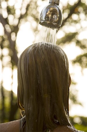 Rear view of a young woman under a shower Foto de stock - Sin royalties Premium, Código: 640-03265739