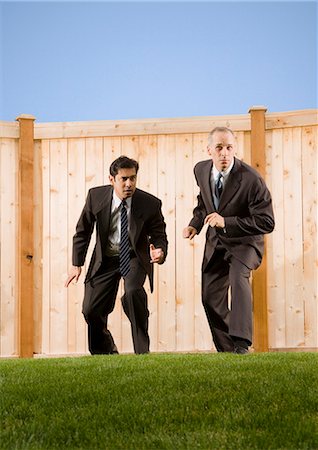 fleeing - Businessmen trying to jump over a fence Stock Photo - Premium Royalty-Free, Code: 640-03260162