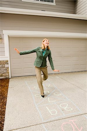 Woman playing hopscotch Stock Photo - Premium Royalty-Free, Code: 640-03260171