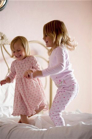 Two girls playing on bed Stock Photo - Premium Royalty-Free, Code: 640-03260193