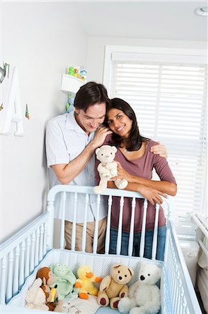 Married couple leaning on baby crib Stock Photo - Premium Royalty-Free, Code: 640-03261335