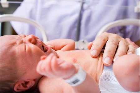 Nurse examining crying newborn in incubator Foto de stock - Sin royalties Premium, Código: 640-03261673