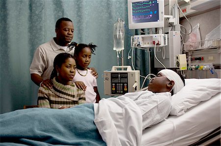 sad black people - Family watching boy in hospital bed with head bandages Stock Photo - Premium Royalty-Free, Code: 640-03261818