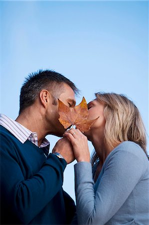 Couple kissing behind leaf Stock Photo - Premium Royalty-Free, Code: 640-03261890