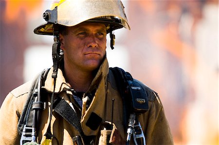 Portrait of a firefighter with fire in background Stock Photo - Premium Royalty-Free, Code: 640-03262191