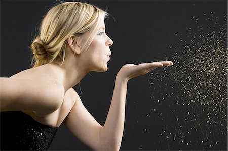 Profile of woman blowing gold dust from hand Stock Photo - Premium Royalty-Free, Code: 640-03262408