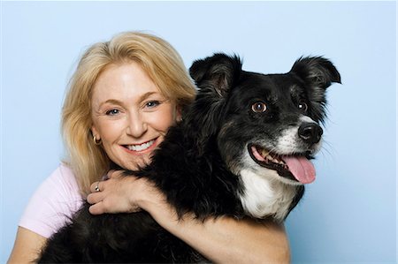 Woman hugging black dog Stock Photo - Premium Royalty-Free, Code: 640-03262474