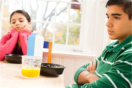 sad child sitting - Girl sulking at breakfast table Stock Photo - Premium Royalty-Free, Code: 640-03262652