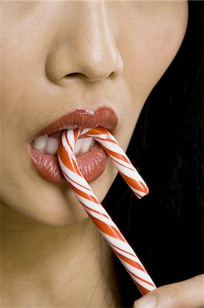 Closeup of woman with red lipstick eating candy cane Stock Photo - Premium Royalty-Free, Code: 640-03262914