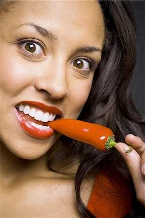 red lipstick - Woman with red lipstick eating red pepper Stock Photo - Premium Royalty-Free, Code: 640-03263165