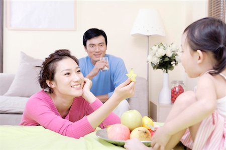 flower for mom asian - Young man and woman with their daughter in the bedroom Stock Photo - Premium Royalty-Free, Code: 642-01734307