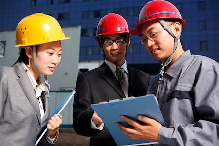 People in safety helmets standing together, talking about work Stock Photo - Premium Royalty-Free, Code: 642-01734780