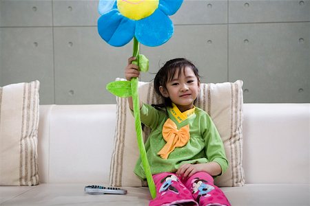 Portrait of girl playing with flower toy Stock Photo - Premium Royalty-Free, Code: 642-01735134