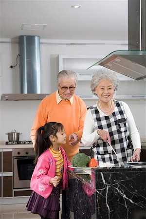 Senior couple and granddaughter cooking in kitchen Stock Photo - Premium Royalty-Free, Code: 642-01735155