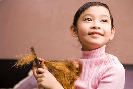 Girl playing with doll, looking up Stock Photo - Premium Royalty-Free, Code: 642-01735262