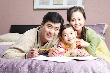 pencil painting pictures images kids - Young couple with daughter lying on bed, smiling, portrait Stock Photo - Premium Royalty-Free, Code: 642-01735277