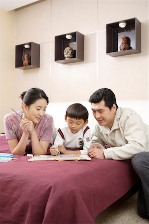 pencil painting pictures images kids - Young couple with son lying down on bed and painting Stock Photo - Premium Royalty-Free, Code: 642-01735358