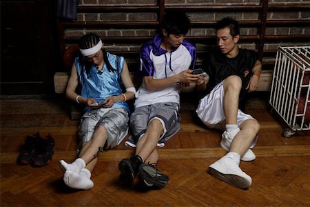 Basketball players holding mobile phones Stock Photo - Premium Royalty-Free, Code: 642-01736028