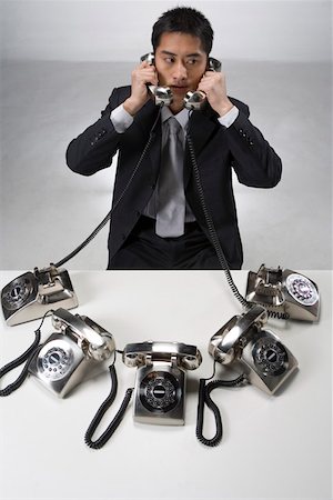 Businessman using telephone, elevated view Stock Photo - Premium Royalty-Free, Code: 642-01736422