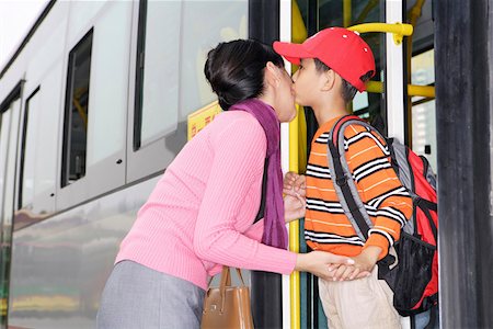 parent child bus - Son standing on bus and kissing Mother Foto de stock - Sin royalties Premium, Código: 642-01737269