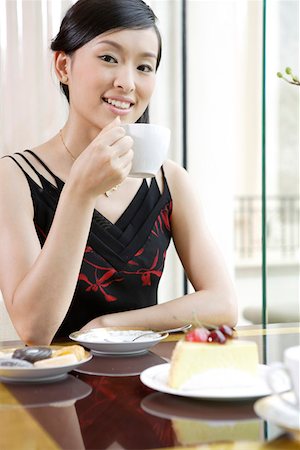 Portrait of young woman holding cup in restaurant Stock Photo - Premium Royalty-Free, Code: 642-01737645