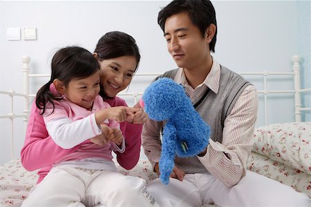 Family playing with a puppet in the bedroom Stock Photo - Premium Royalty-Free, Code: 642-01732760