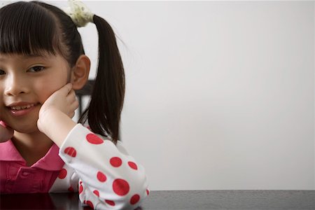 Girl sitting on chair, smiling, portrait Stock Photo - Premium Royalty-Free, Code: 642-01732844