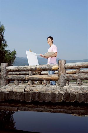 fence painting - Young man painting by fence on bridge Stock Photo - Premium Royalty-Free, Code: 642-01733324