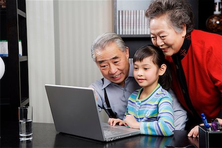 une jeune fille et son grand-père et grand-mère jouant l'ordinateur Photographie de stock - Premium Libres de Droits, Code: 642-02006199