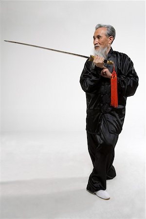 an old man practicing a Chinese sword Foto de stock - Sin royalties Premium, Código: 642-02006511